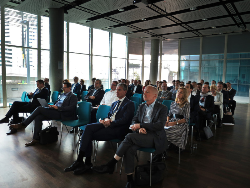 people in suits on a conference listening whilst sitting in chairs