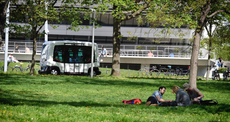 Self-driving-bus and a park with people lying in it