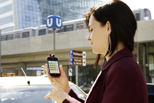 A person standing in front of the underground using the Linking Danube app