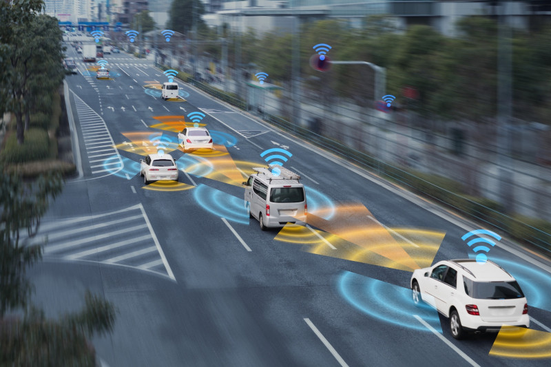 cars on a street with wifi-signals on top and going to the side